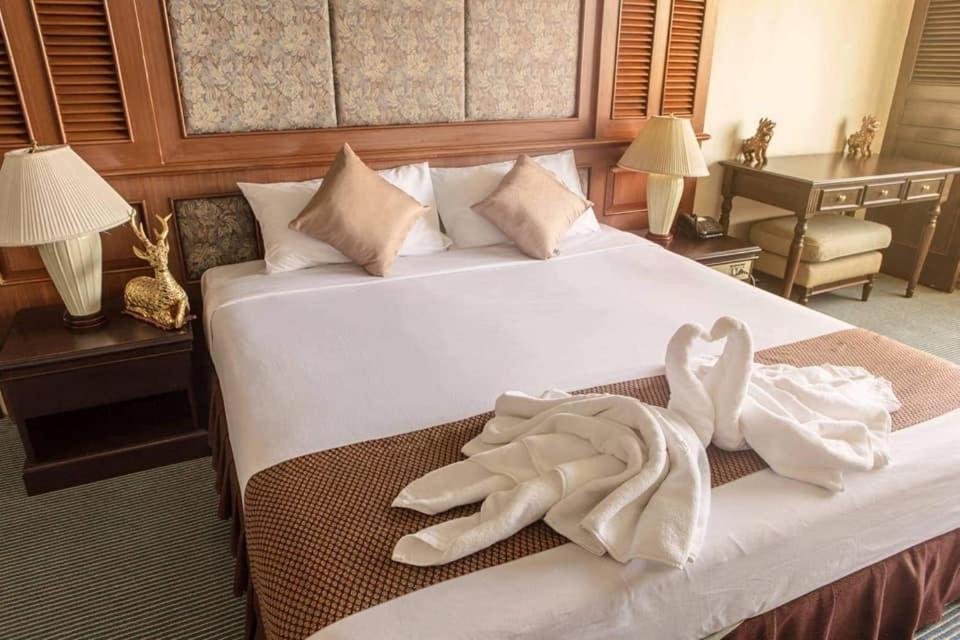 a hotel room with a bed with two towels on it at Lampang Wieangthong in Lampang