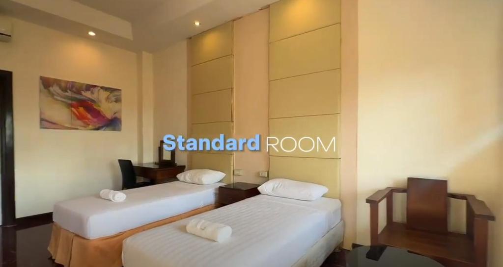 Sampong的住宿－Tugsaw Resort，一间设有两张床的客房,墙上有标志