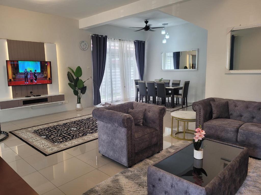 ein Wohnzimmer mit 2 Sofas und einem TV in der Unterkunft Ana Homestay D'Airport in Malakka