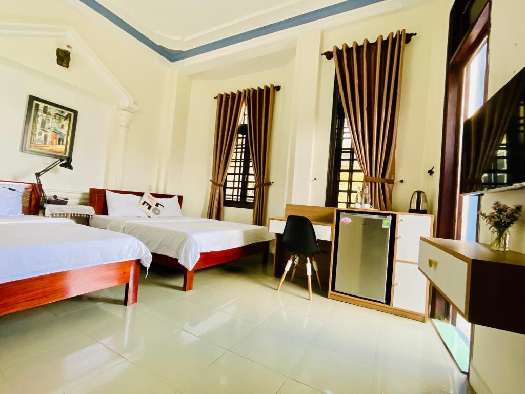 1 dormitorio con 2 camas y TV. en EVA Hotel en Hue