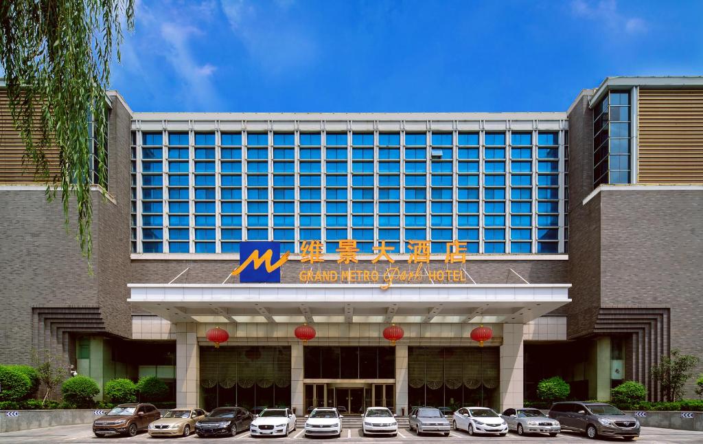 un hotel con coches aparcados delante en Grand Metropark Hotel Shandong en Jinan