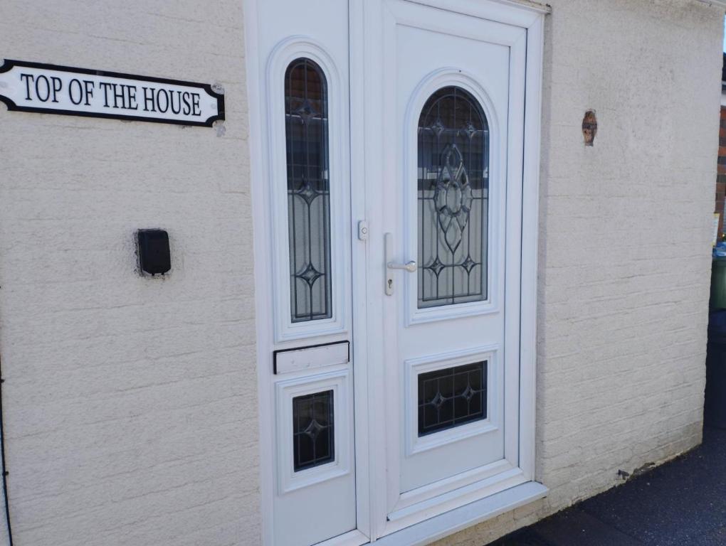 a white door with two windows on a building at Top of the House in Bognor Regis