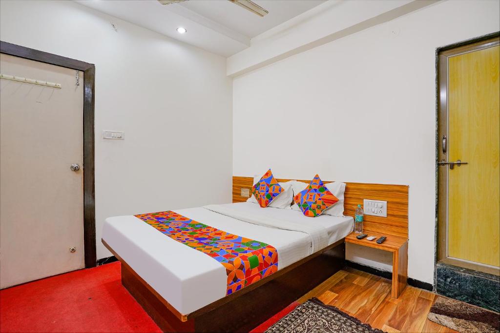 a bedroom with a bed with a colorful blanket on it at FabExpress Sai Chatra in Nashik