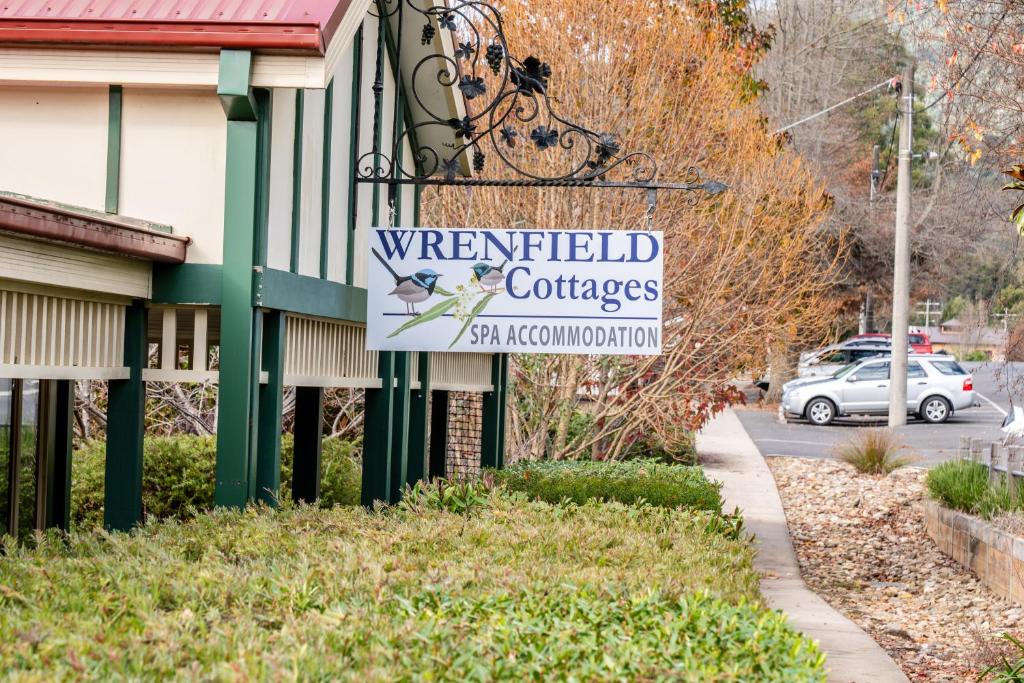 un cartello per un college di Wrenfield sul lato di un edificio di Wrenfield Cottages a Marysville