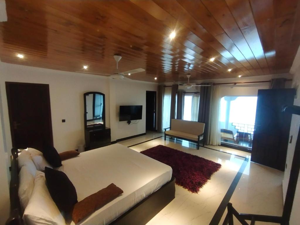 Sellamah beach Hotel في ترينكومالي: غرفة كبيرة بها سرير وأريكة