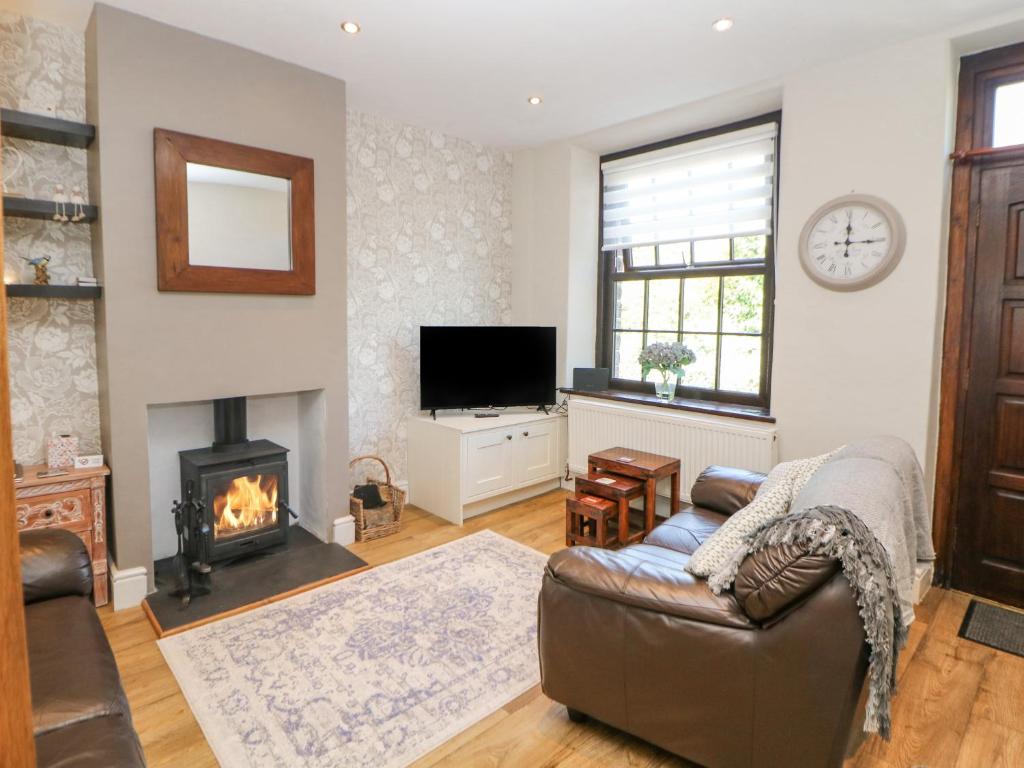 a living room with a couch and a fireplace at Shenton Terrace in Buxton