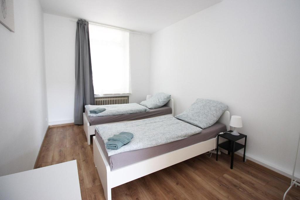 um pequeno quarto com uma cama e uma janela em Chic Apartment with Balcony em Wuppertal