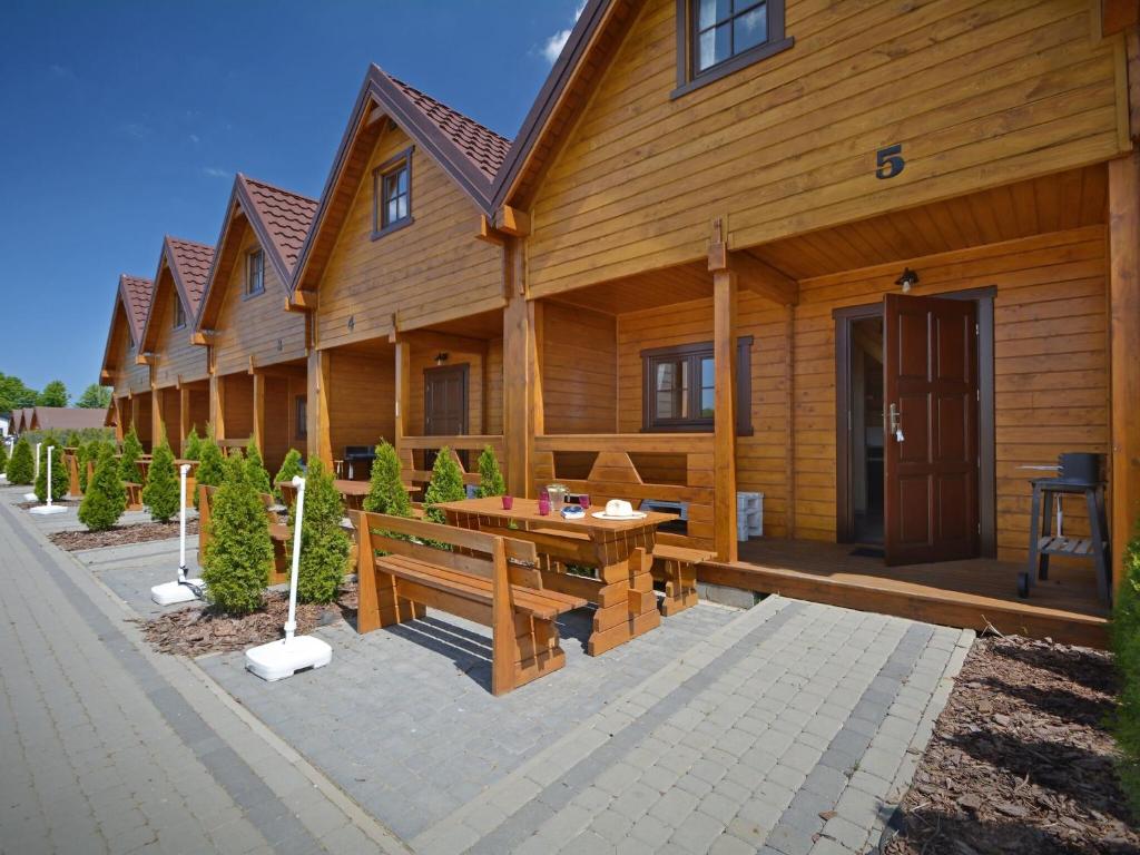 a wooden house with a wooden table in front of it at Nice holiday home located 800 m from the sea in Mielenko