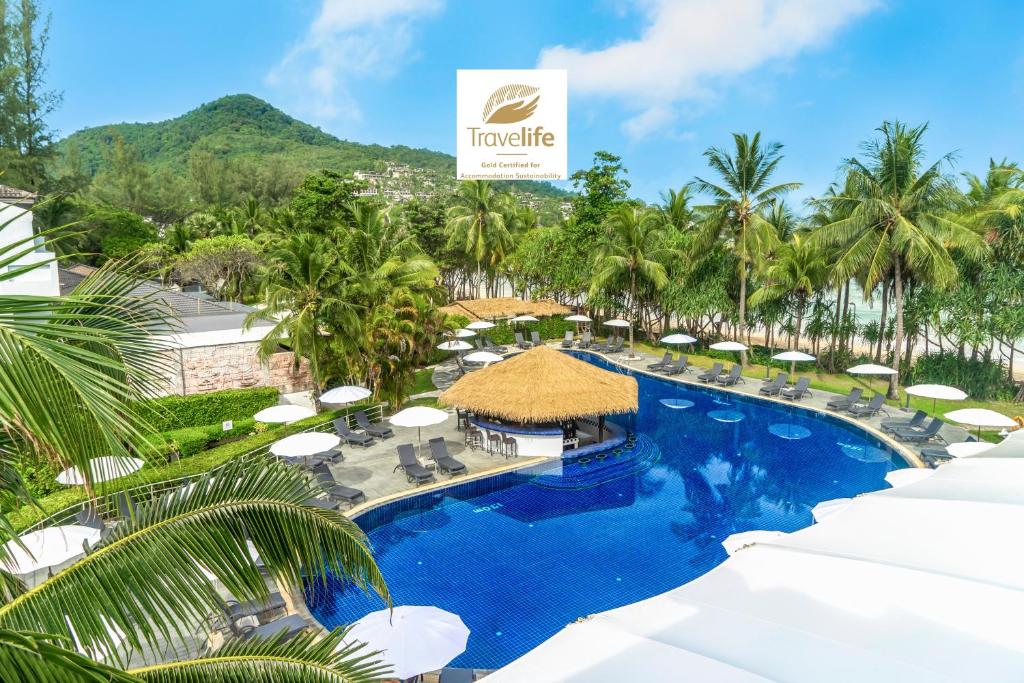 una imagen de una piscina del complejo con palmeras en Sunprime Kamala Beach, en Kamala Beach