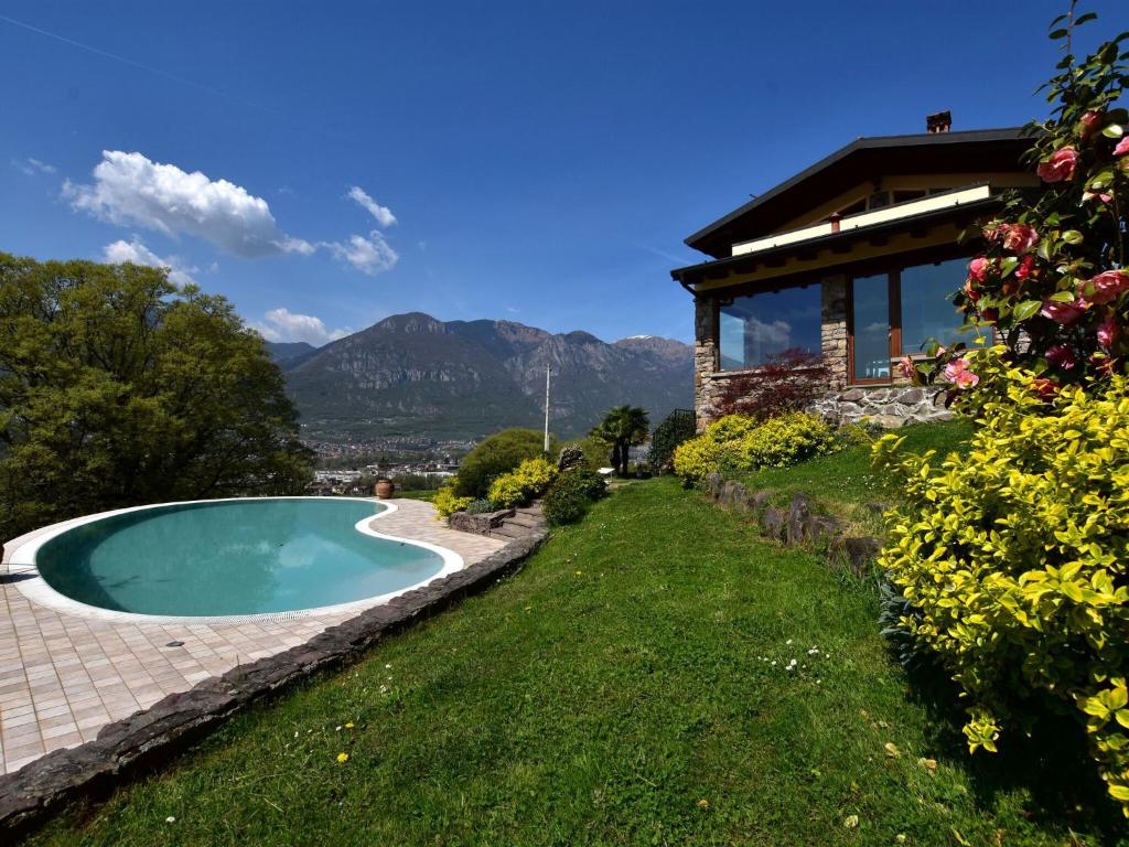 a swimming pool in a yard next to a house at Villa in Pisogne with pool garden and lake view in Pisogne