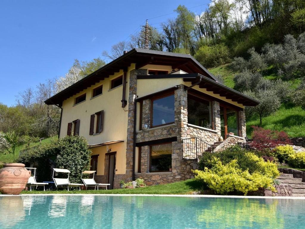 a house with a swimming pool in front of a house at Villa in Pisogne with pool garden and lake view in Pisogne