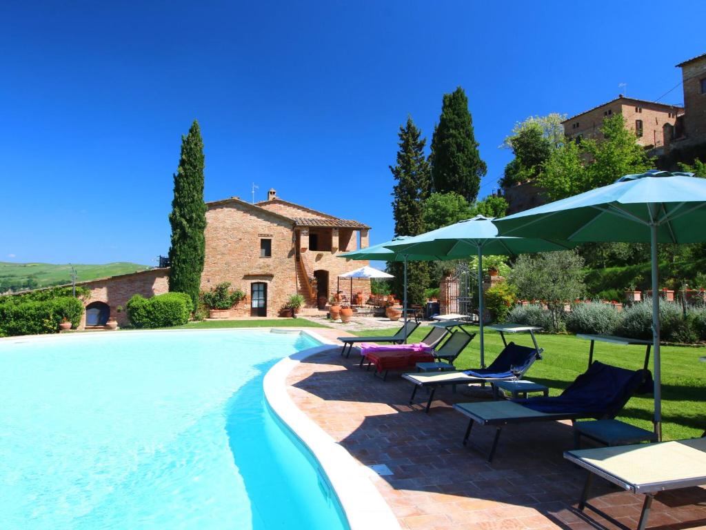 - une piscine avec des chaises longues et des parasols dans l'établissement Attractive Farmhouse in Montalcino with Terrace, à San Giovanni dʼAsso