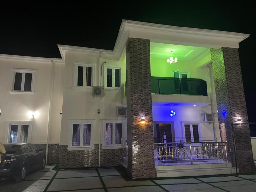 a large white house with blue lights on it at Havre Luxury Apartment in Abuja