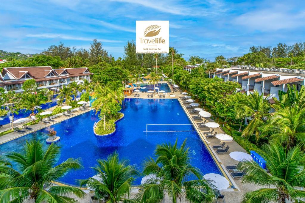 - une vue aérienne sur la piscine du complexe entourée de chaises et de palmiers dans l'établissement Sunwing Kamala Beach, à Kamala Beach