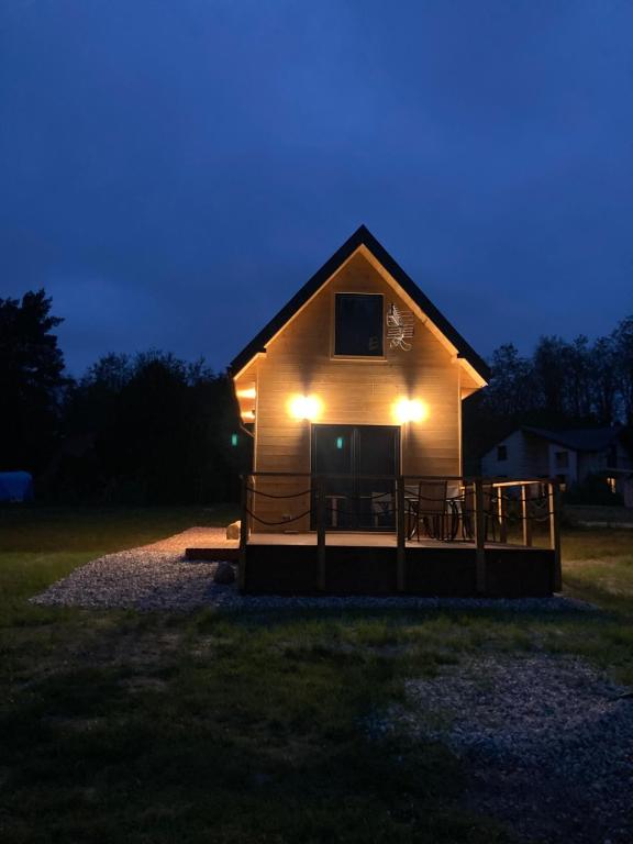 Domek nad rzeką في Wierzchlas: منزل فيه اضاءه في الليل