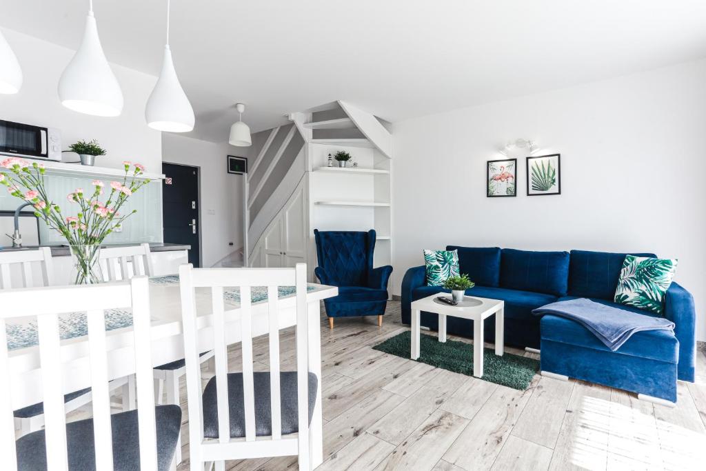 a living room with a blue couch and blue chairs at DOMKI APARTAMENTOWE BARKA in Karwia