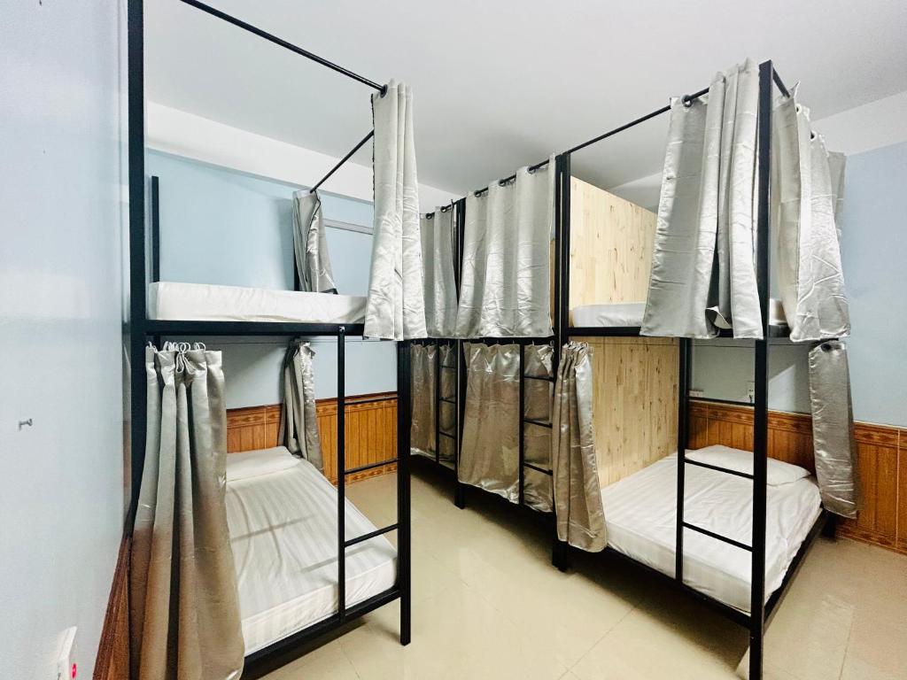 a room with three bunk beds in a room at Majestic Hostel - Tour & Motorbike Rental in Ha Giang