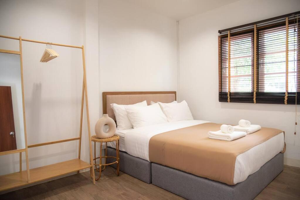 - une chambre avec un lit et 2 serviettes dans l'établissement Ray's Home,3BR with front yard,walkable to Nimman, à Chiang Mai