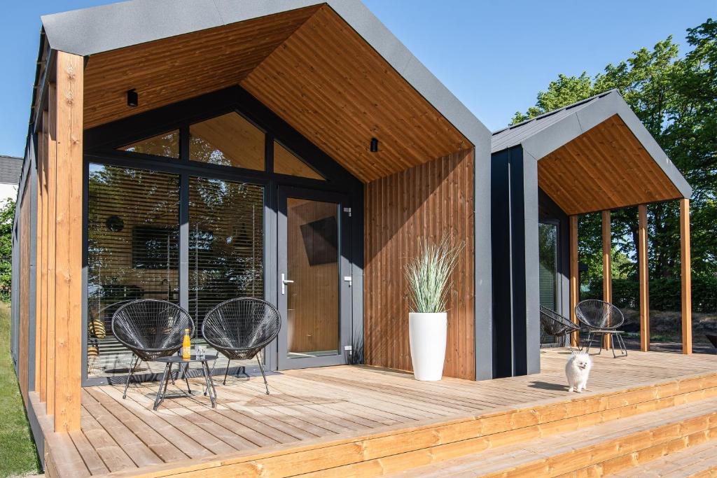 a wooden deck with chairs and a house at Stodoły Słona Zatoka in Władysławowo