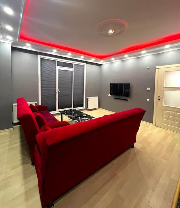uma sala de estar com um sofá vermelho e uma televisão em Venüs apart em Istambul