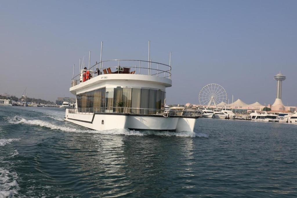 a boat on the water with a ferris wheel in the background at Butina Chaters in Abu Dhabi