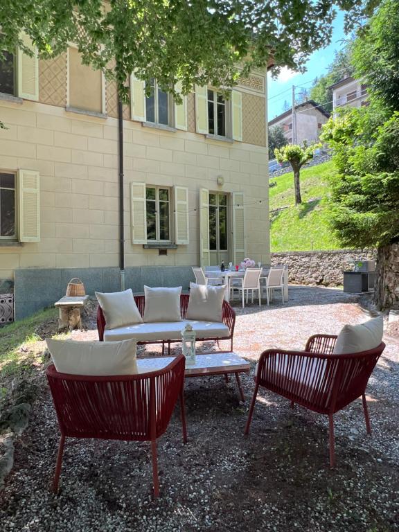 un grupo de sillas y una mesa frente a un edificio en Villa Pia Lena, en Magreglio
