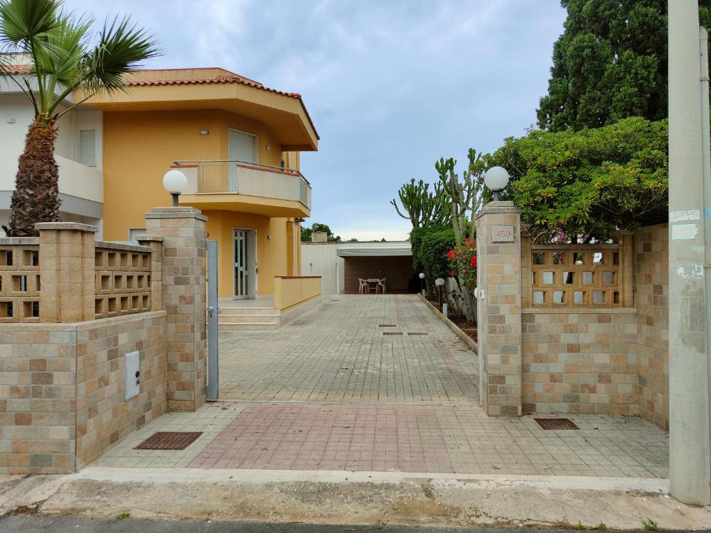 a house with a fence and a brick driveway at Villa Angelina in Marausa