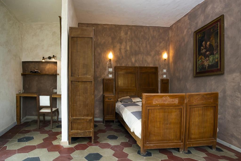 Antica Casa Santa Maria في Pomaro Monferrato: غرفة نوم بسرير ومكتب وطاولة