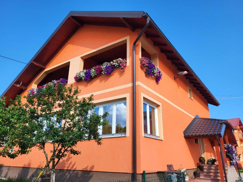 dom z kwiatami na boku w obiekcie Rooms Sapina w mieście Korenica