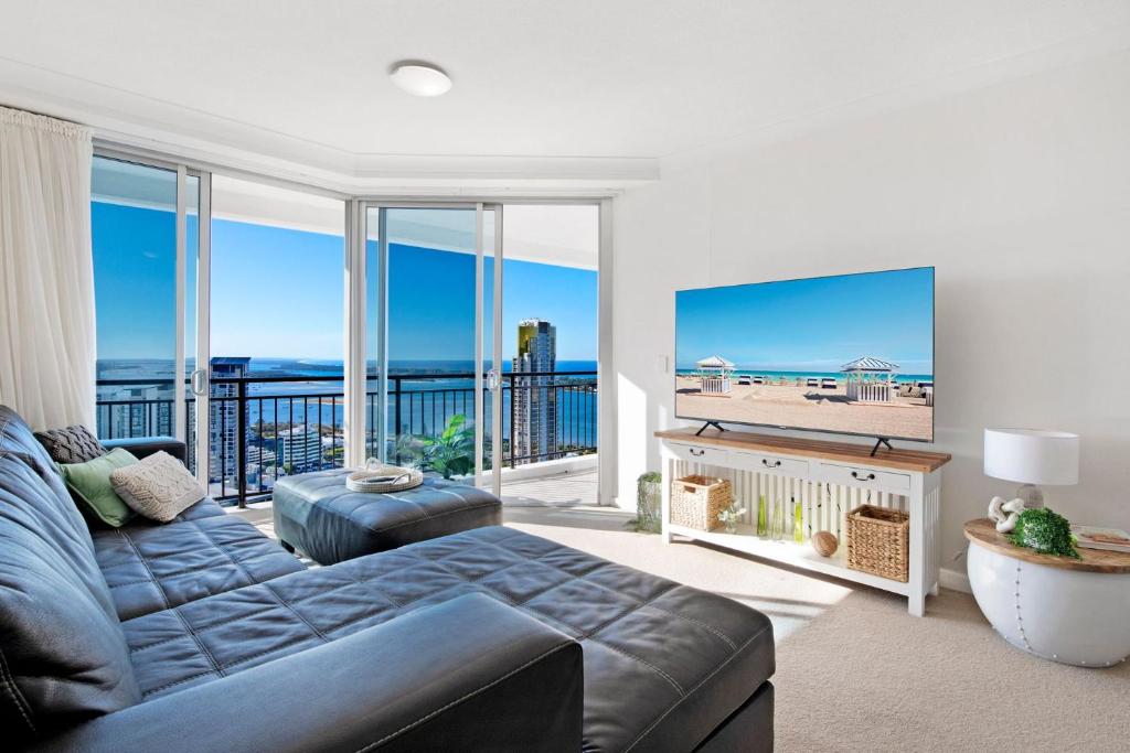 een woonkamer met een bank en uitzicht op de oceaan bij Ocean Views Apartment in Southport Central in Gold Coast
