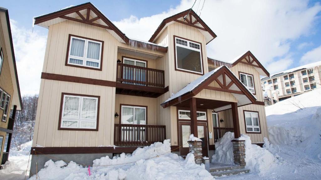 una casa está cubierta de nieve en Niseko Alpine Apartments, en Niseko