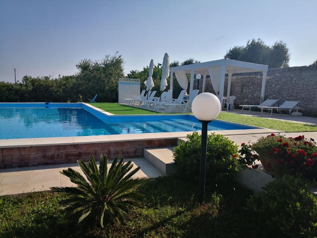 a swimming pool with chairs and a gazebo at B&B Villa Lena in Turi