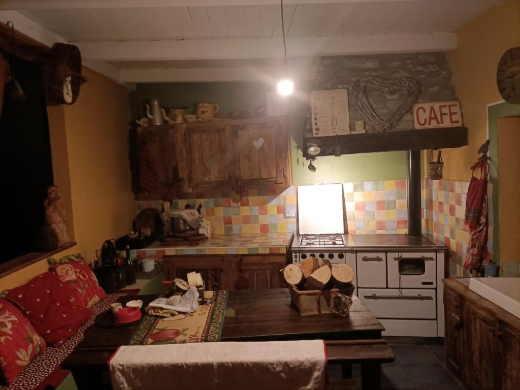 a kitchen with a stove and a table in a room at Maison du Mont in Aosta