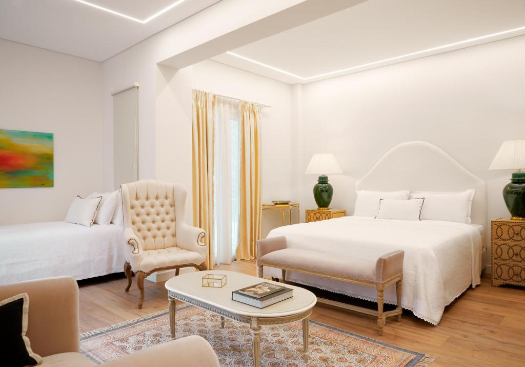 una camera bianca con due letti e un tavolo di Old Town Luxury Suites Acropolis ad Atene