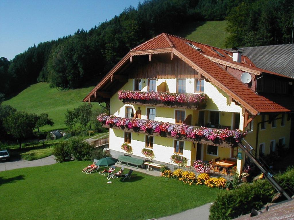 une maison avec des fleurs sur son côté dans l'établissement Gesundheitshof Lohninger, à Mondsee