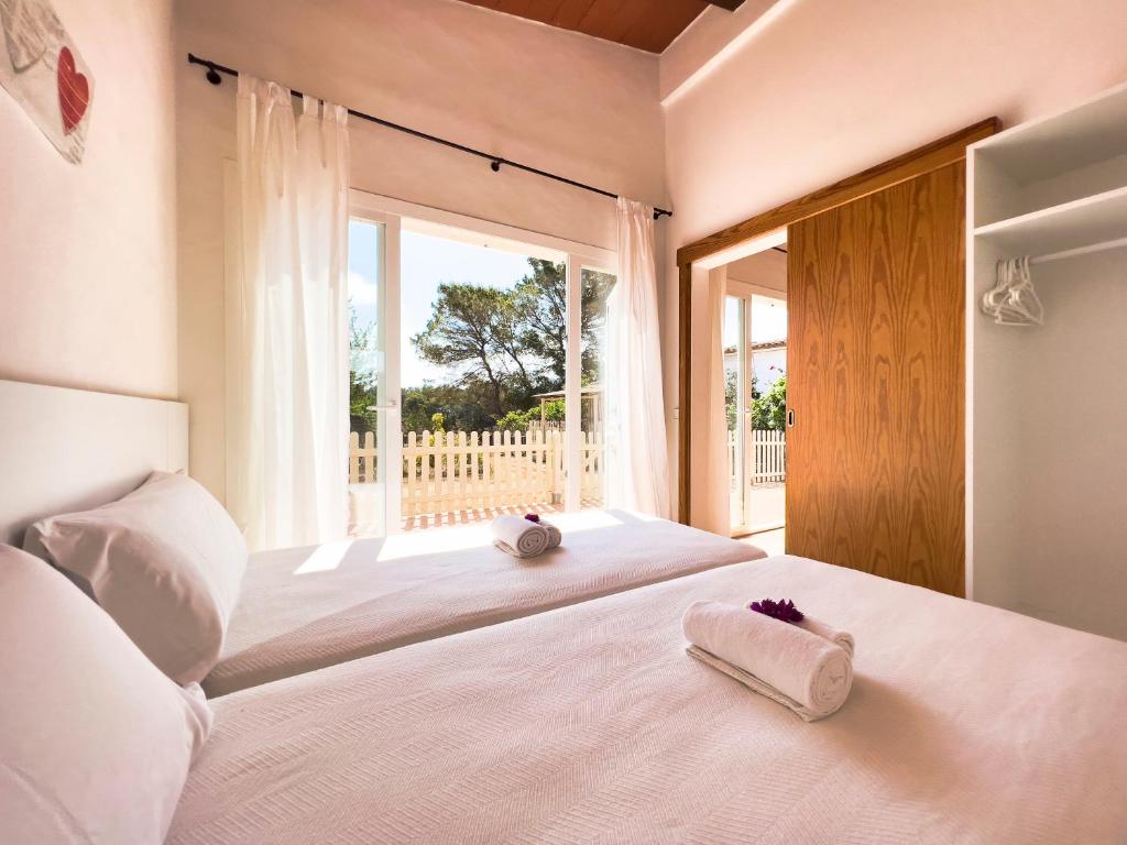 a bedroom with a large bed with towels on it at En plena naturaleza a 800m Playa Migjorn in Playa Migjorn