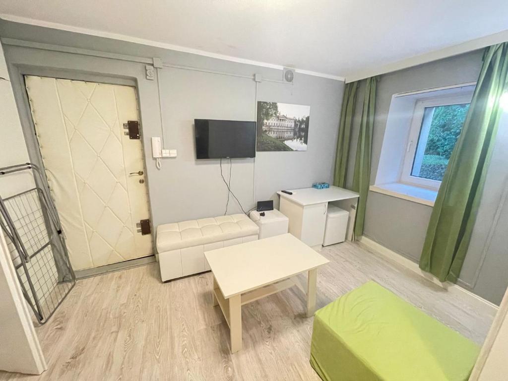 a small living room with a couch and a tv at Your Apart Saska Kępa in Warsaw