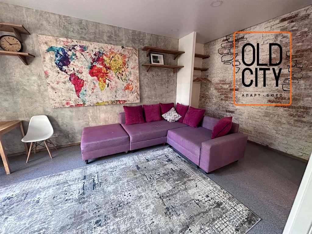 una sala de estar con un sofá púrpura y un mapa en OLD CITY Loft, en Öskemen