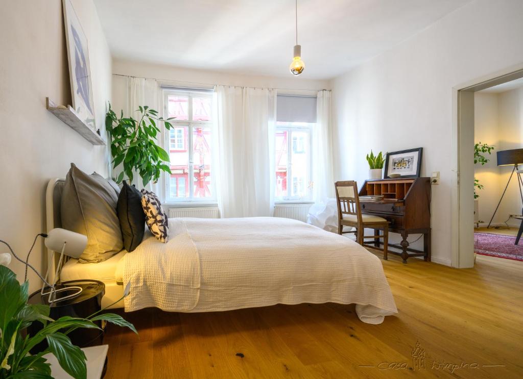 a bedroom with a bed and a desk in it at Casa Wimpina - geschmackvolles Appartement im Herzen der Altstadt in Bad Wimpfen