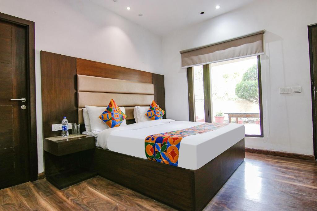 ein Schlafzimmer mit einem großen Bett und einem Fenster in der Unterkunft FabHotel Paradise Ville Resort in Bhīm Tāl