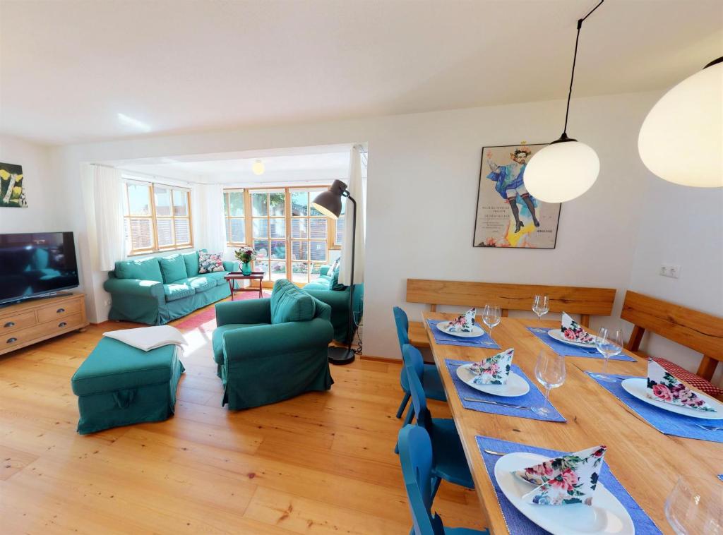 a living room with a dining room table and chairs at Ferienhaus im modernen Landhauscharme mit Bergblick und Garten in Bischofswiesen