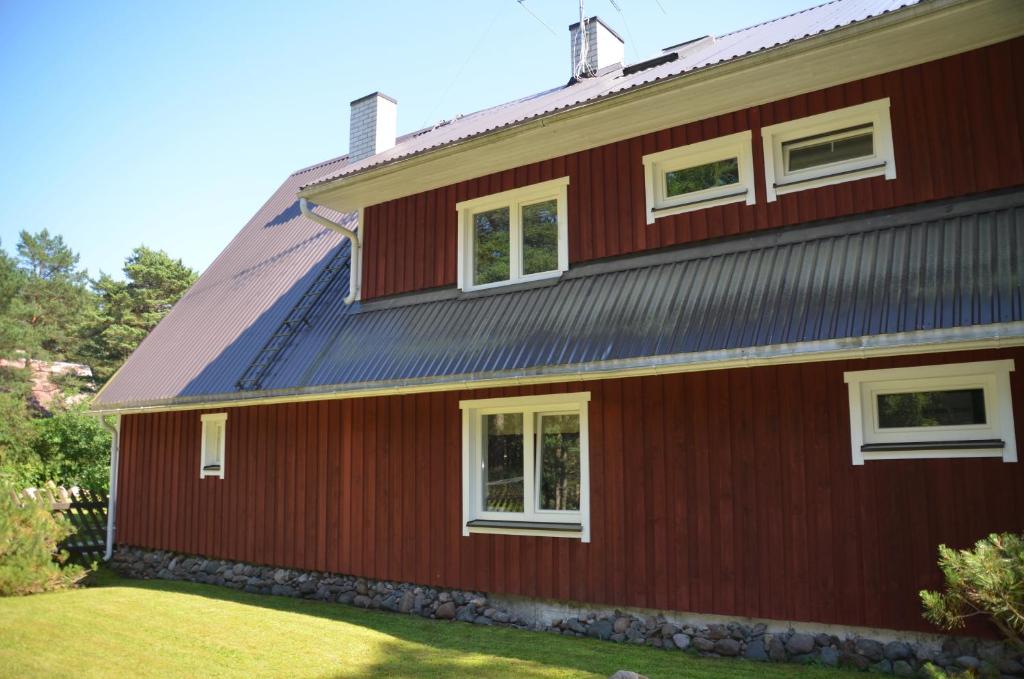 a red house with a metal roof at Lohusalu Apartment in Lohusalu