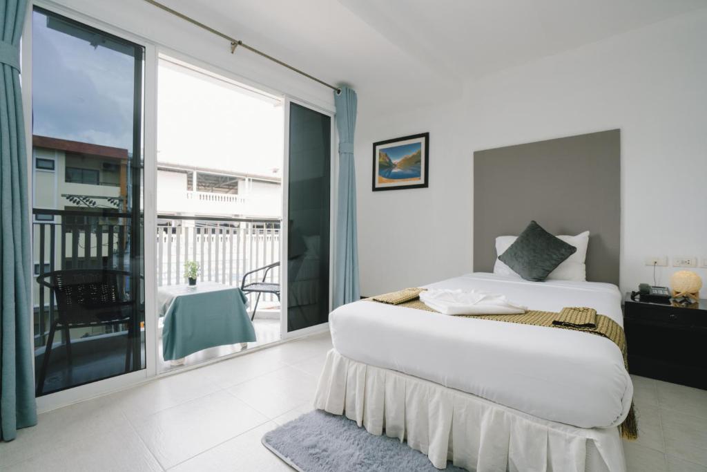 een slaapkamer met een bed en een balkon bij Noble House Patong in Patong Beach