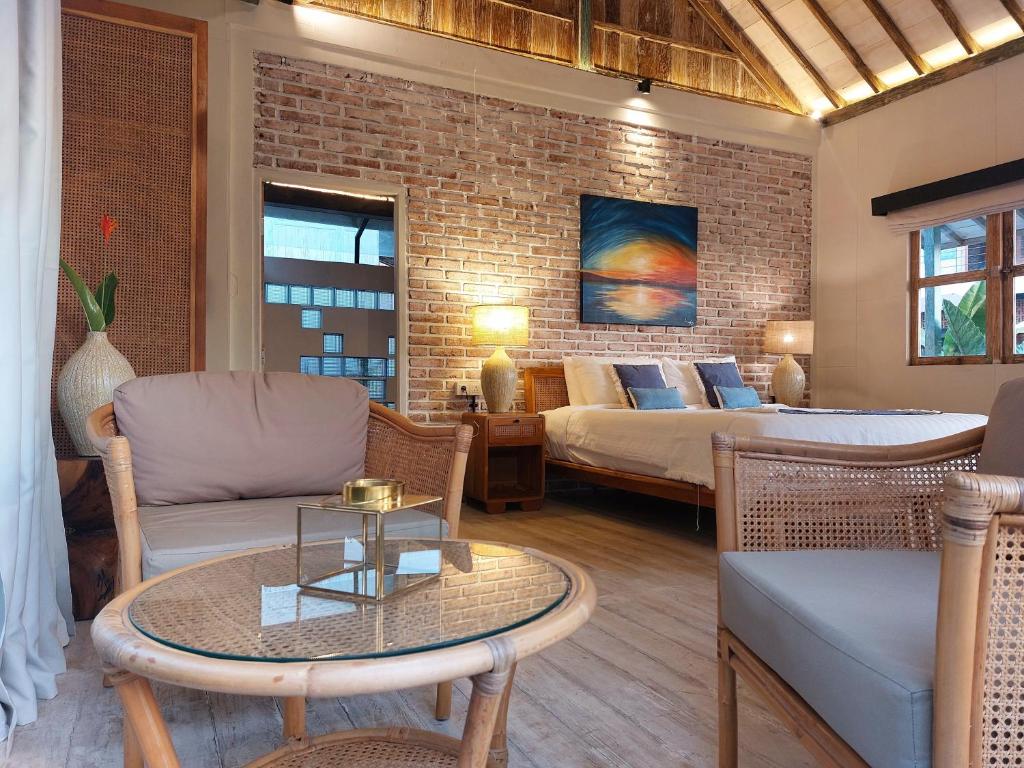 a living room with a bed and a table at Spaces Bali Unique Boutique Hotel in Munggu