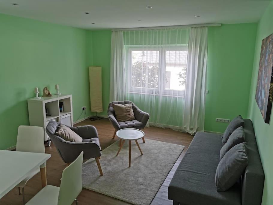salon z zielonymi ścianami, kanapą i krzesłami w obiekcie Wandern, Reiten und die Seele baumeln lassen w mieście Dickschied
