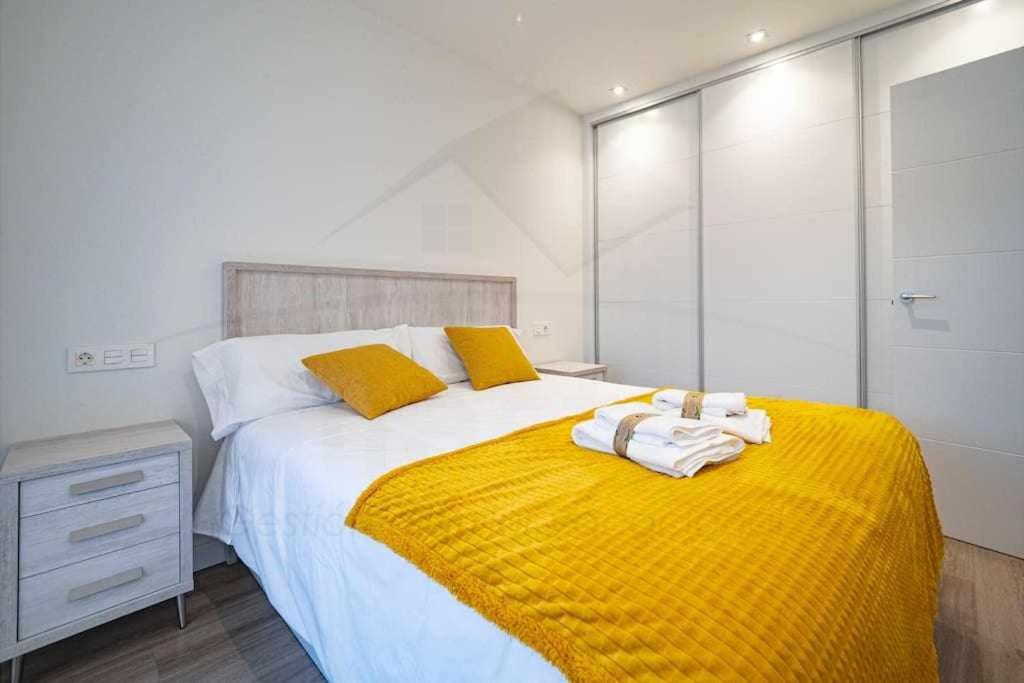 a bedroom with a large bed with yellow blanket at La Terraza De Loyola in Oviedo