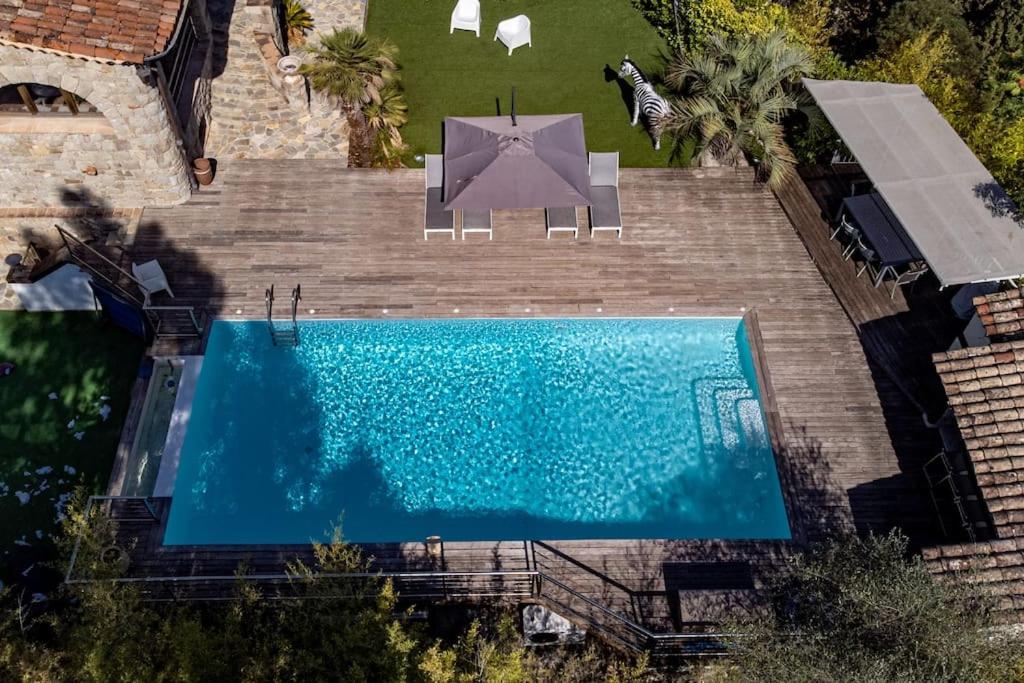 uma vista superior de uma piscina com um guarda-sol em Bas de villa- Bastide zebra em Contes