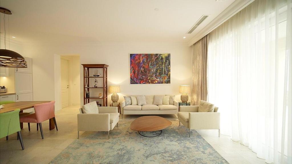 uma sala de estar com um sofá, cadeiras e uma mesa em Lustica Bay Apartment Honey By 2bhome em Radovići