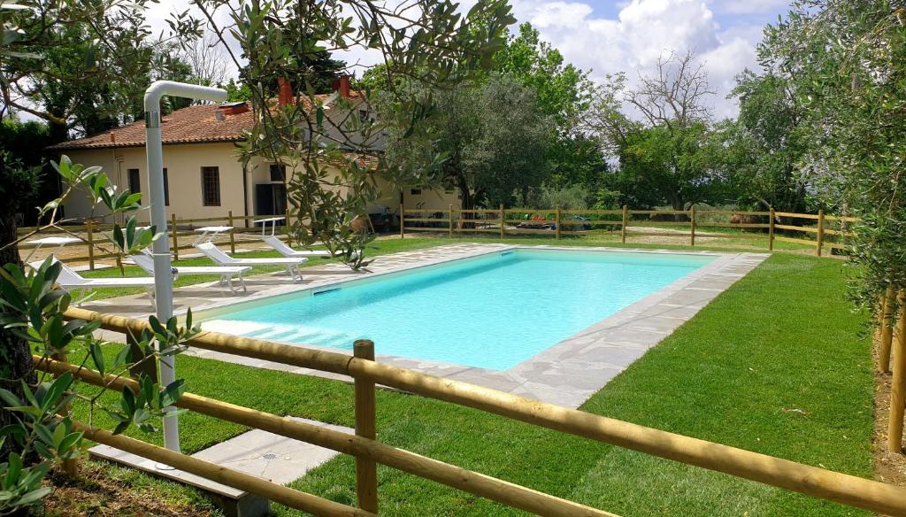 a swimming pool in a yard next to a fence at Il Sottolo in Florence