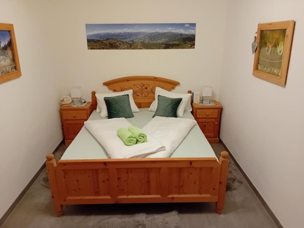 a bedroom with a large wooden bed with green pillows at Much`s Bergstüberl in Wattenberg